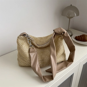 Woven straw tote bag with PU shoulder strap and silver metal chain detail in minimalist style