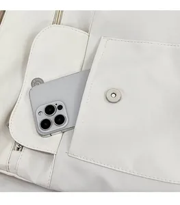 Detail der weißen Canvas-Tasche mit mehreren Taschen, Magnetklappe und Smartphone-Vergleich