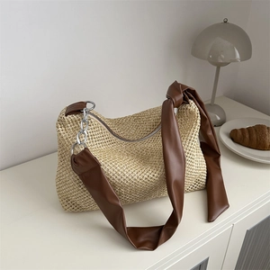 Chic beige straw hobo tote bag with brown leather knotted strap and silver chain detail
