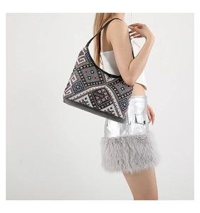 Detailed view of bohemian canvas tote featuring geometric woven patterns and black leather straps