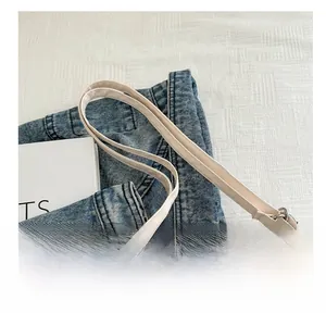 Detail showing the slender handles and connection points of this white nylon tote bag