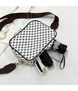 Interior capacity detail of a white patterned crossbody bag with phone, umbrella and wallet