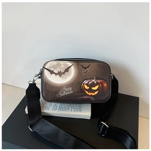 Detail of Halloween crossbody bag featuring pumpkin print and wide black strap