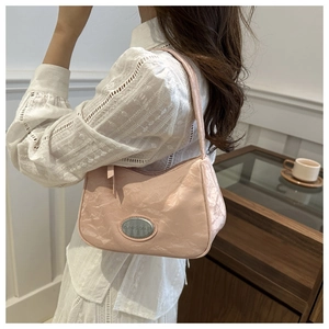 Detail of pink shoulder bag featuring landscape texture and oval metal logo plate