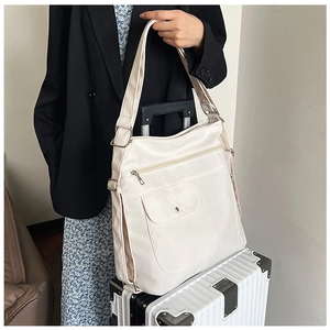 Detail der cremeweißen Reisetasche mit praktischer Trolley-Schlaufe für Kofferbefestigung