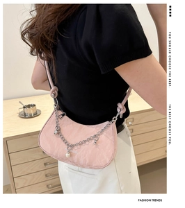 Detailed view of pink moon bag with metal chain, pearl charm and pleated texture design