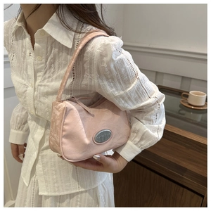 Chic pink underarm bag with silver logo worn with elegant white lace dress in cozy cafe