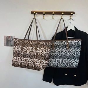 Bolsos tote clásicos con estampado de leopardo marrón y gris colgados en una pared blanca
