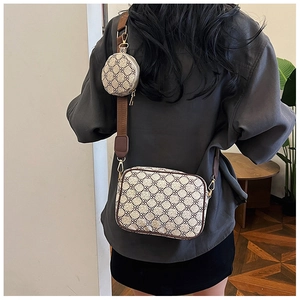 Detail of retro monogram crossbody bag with wide strap and round coin purse attachment
