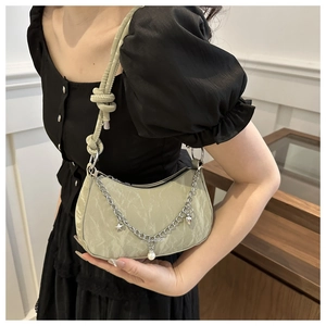 Detail of sage green crescent bag with knotted rope strap and pearl chain charm