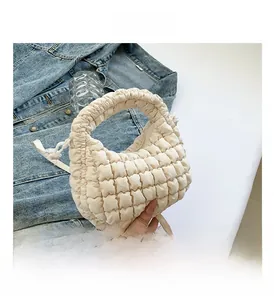 Close-up of beige quilted bubble mini tote bag with detachable strap and soft texture