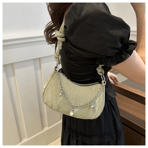 Detail of light green ruched nylon underarm bag with silver chain and star heart charms