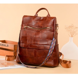 Detail view of brown vintage leather backpack with ethnic geometric patterned shoulder strap