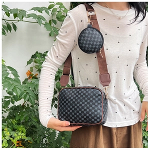Detail of retro crossbody bag with geometric honeycomb texture and brown wide strap
