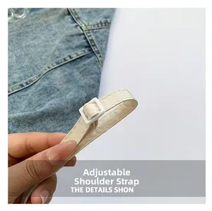 Detail of adjustable cream shoulder strap with white stitching and plastic buckle