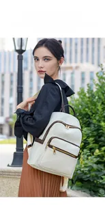 Close-up of white woven leather backpack featuring golden zippers and brown edge paint details