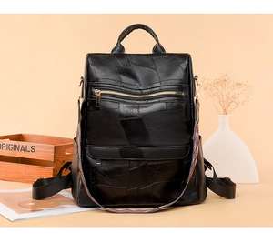 Detail of black patchwork PU leather backpack with a colorful woven shoulder strap