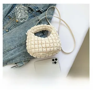 Detail of white cloud pleated mini tote bag with quilted texture and crossbody strap