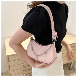 Detail of pink crescent underarm bag with silver chain, pearl charms and pleated texture