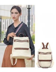 Detail of off-white PU leather backpack with brown trim and colorful geometric strap