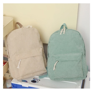 Détail de sacs à dos en velours côtelé beige et vert menthe avec poches zippées devant