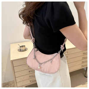Detail view of pink half-moon underarm bag with silver chain and pearl charms