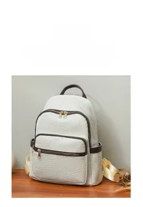 Detail of woven faux leather backpack showing white texture and brown trim handles
