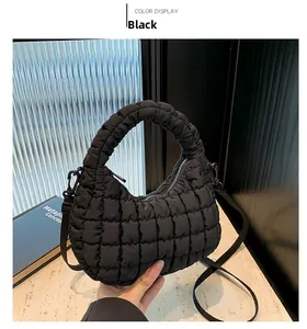 Detail of black quilted cloud tote bag with padded handle and detachable shoulder strap