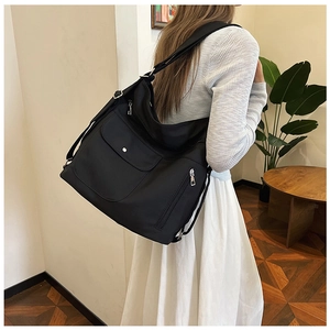 Detaillierte Seitenansicht einer großen schwarzen Hobo-Tasche mit mehreren Funktionstaschen