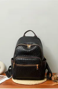 Detail of woven faux leather texture and golden zippers on a black fashion backpack