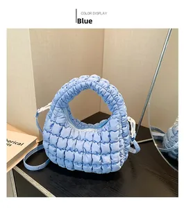 Detail shot of blue puffy quilted mini tote bag showing bubble texture and crossbody strap