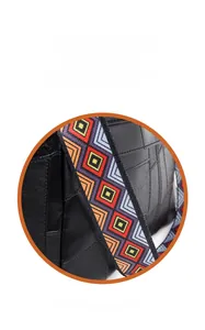 Detail of colorful geometric knitted shoulder strap on black litchi leather backpack