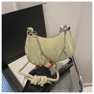 Detail of light green PU leather underarm bag with marble texture and pearl heart charms
