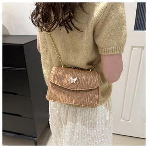 Brown woven straw crossbody bag featuring a white butterfly buckle and golden metal chain
