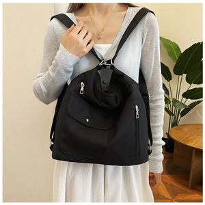 Details eines schwarzen Nylon-Rucksacks mit Klappentasche und silbernen Metallteilen
