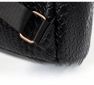 Close-up of black crocodile texture leather and reinforced triangular strap stitching