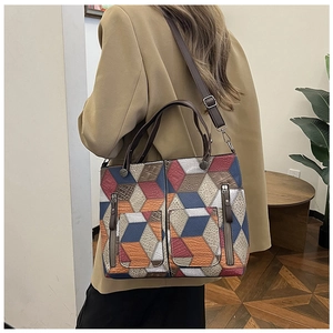 Detail of the 3D geometric patchwork tote bag with multiple zip pockets and dual handles