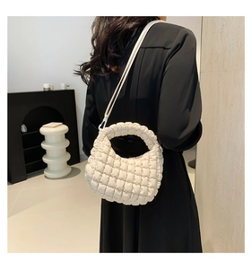 Chic beige quilted tote bag with pleated texture styled in a modern home interior