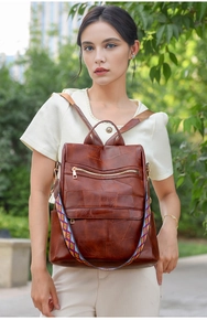 Brown PU leather backpack with patchwork design and patterned strap on a female model