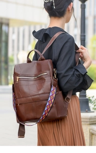 Brown faux leather backpack with geometric strap and decorative stitching detail
