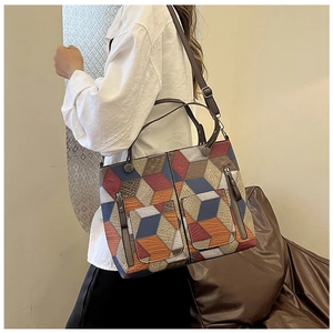 Detail of vintage geometric patchwork tote bag with 3D diamond pattern and zippers