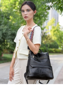 Detail of black PU leather backpack showing geometric patchwork and woven boho strap