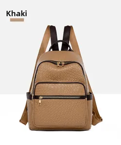 Close-up of khaki woven leather backpack showing metal zippers and textured surface