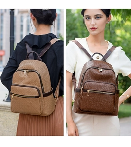 Detail showing woven faux leather texture and metallic zippers of the brown backpack