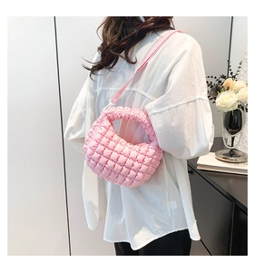 Detail of light pink quilted mini tote bag with bubble texture and adjustable strap