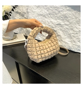 Close-up of beige quilted puffy tote bag with bubble texture and top handle detail