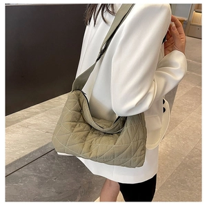 Quilted sage green crossbody bag with wide shoulder strap shown on model for size and style