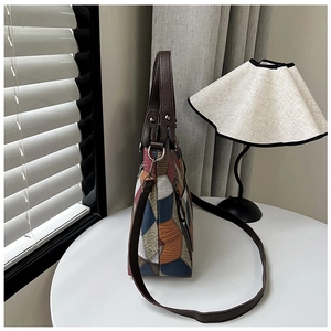 Detail of color-block tote bag featuring ostrich and crocodile embossed leather textures