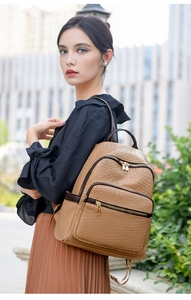 Outdoor shot of camel woven leather backpack showing size on model's back