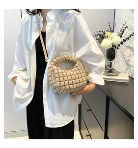 Detail of beige quilted cloud tote bag with detachable shoulder strap and pleated texture